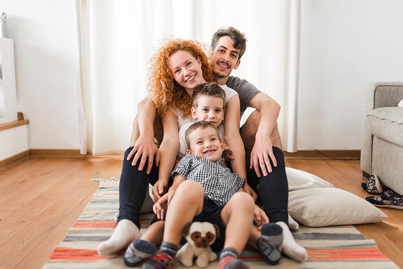 Eine Familie sitzt auf einem Teppich